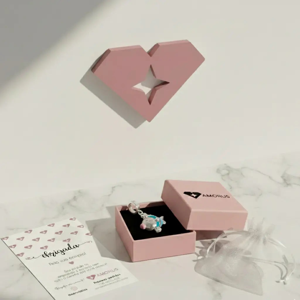 Berloque peixe azul embalado na caixa rosa Amorus com cartão personalizado e saquinho de organza