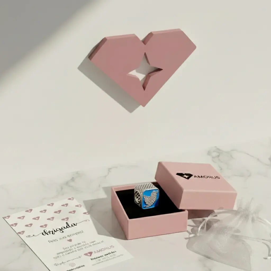 Pingente de prata 925 com logo do Twitter cravejado em azul, dentro da caixa rosa da Amorus com embalagem para presente