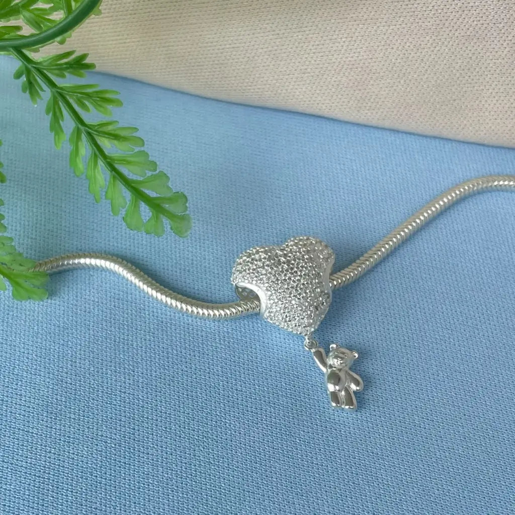 Pingente coração cravejado em Prata 925 com detalhe de ursinho pendurado, design delicado e sofisticado