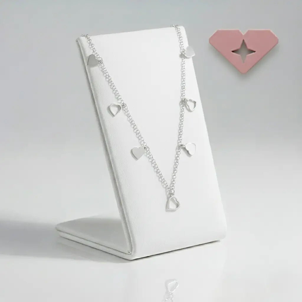 Colar choker prata 925 com pingentes de corações lisos e vazados, exposto em suporte branco — joia romântica e elegante.