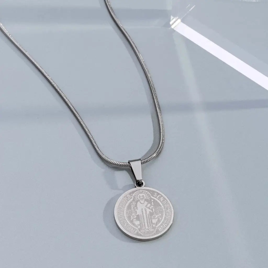 Pingente São Bento médio em aço inox prateado com corrente prateada discreta e elegante