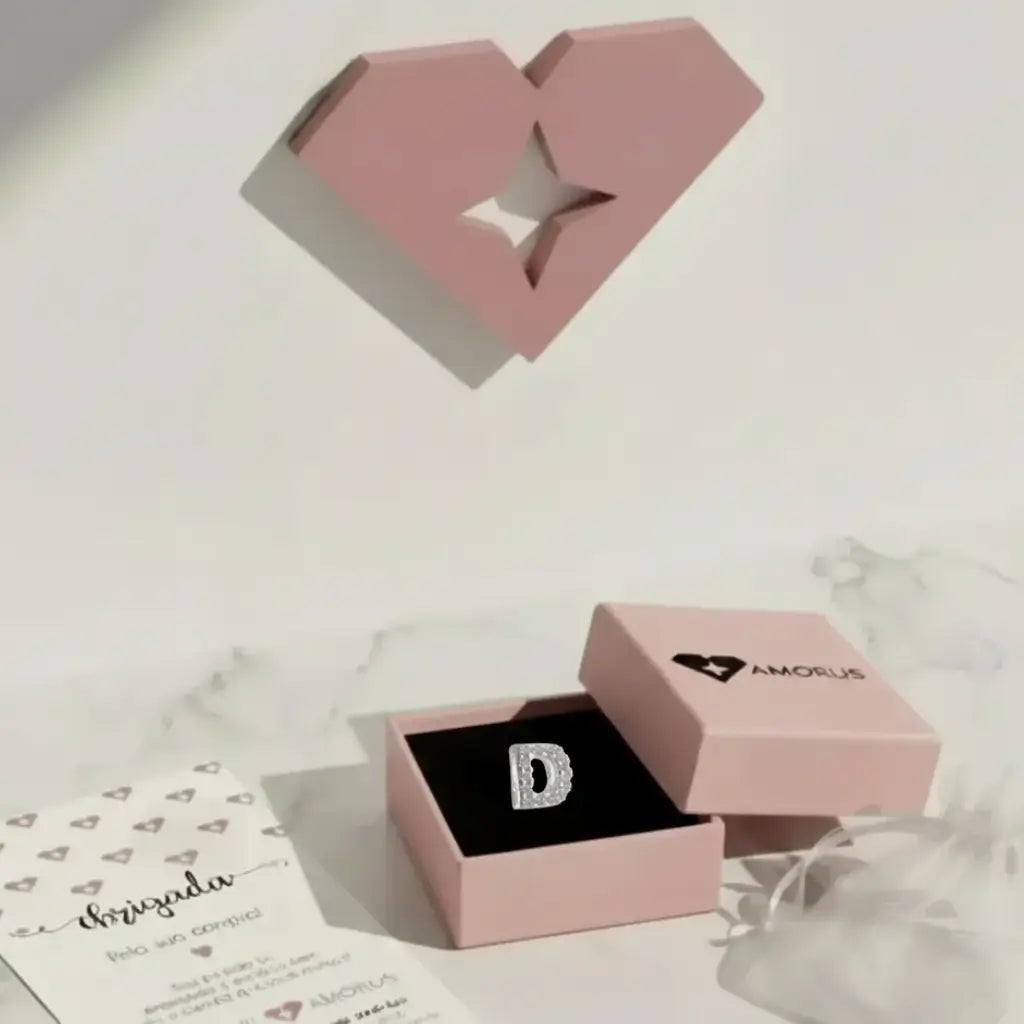 Pingente Letra D em Prata 925 cravejado exibido em caixa presenteável rosa da marca Amorus.